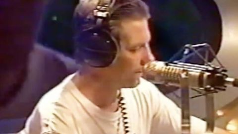 un homme à moustache devant un micro de radio