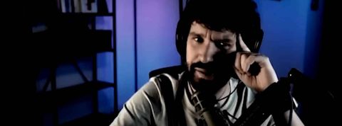 une homme barbu affiche un air suspicieux