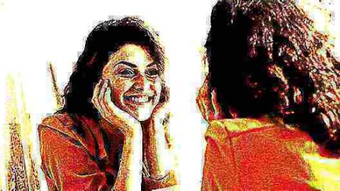 Une femme qui se regarde dans un miroir en souriant