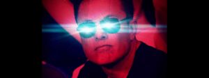 elon muske en filtre rouge avec les yeux bleu qui brillent.