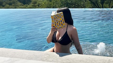 une jeune femme dans la mer qui lit un livre