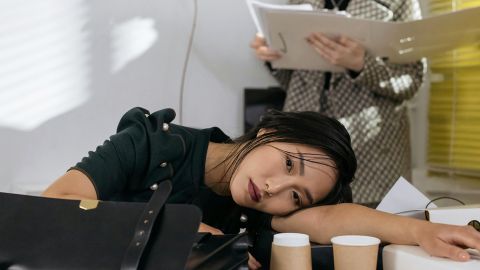 femme allongeant sa tête sur une table de bureau