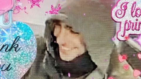 un homme en capuche entouré d'inscriptions roses