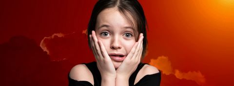Une petite fille inquiète sur un fond de ciel rouge
