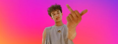 Un jeune homme qui fait le signe fuck sur fond aux couleurs Instagram