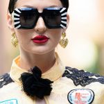 Une femme brune très stylée avec des lunettes noires