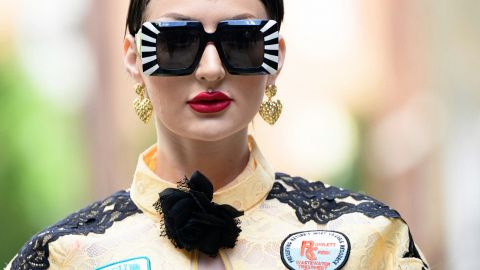 Une femme brune très stylée avec des lunettes noires
