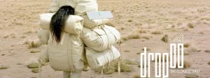 Une femme brune de dos est ensevelie sous des sacs en textile blanc
