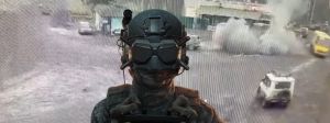 Un soldat avec un masque pour drone FPV tet derrière lui de la fumée