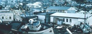 Vue d'une ville dévastée par une tempête avec des bateaux échoués et des maisons dévastées