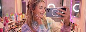 Une jeune femme influenceuse dans sa salle de bains emplie de produits de beauté