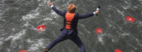 Un journaliste qui saute dans l'eau où flottent des logos YouTube